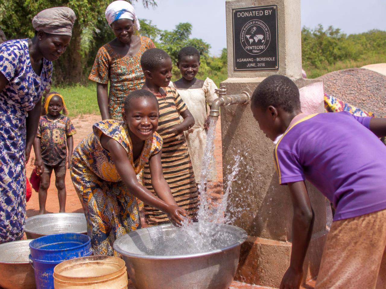Community members collecting clean water from a borehole standpipe
