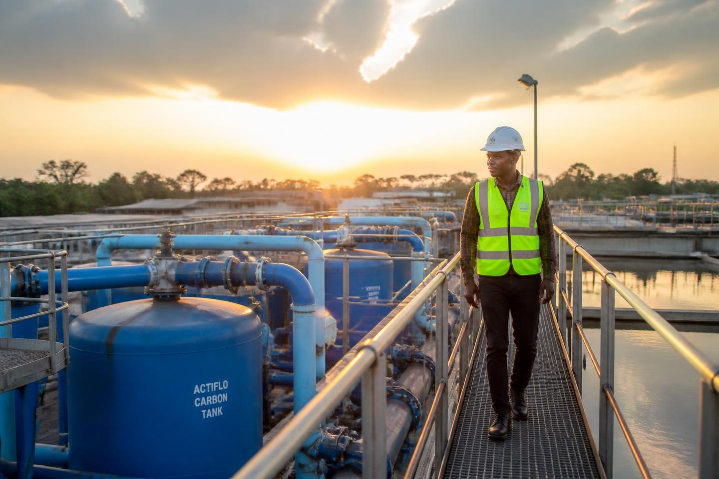Plant operator walking the gantry of an industrial water treatment plant